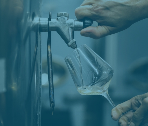White wine poured from a steel vat