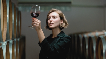 Women looking at wine glass in cellar