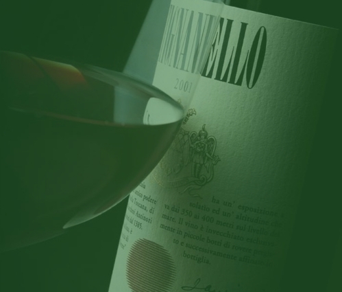 Tignanello 2001 label beside a glass of red wine, one of the original Super Tuscan wines