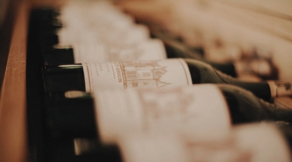 Bottles of Chateau Haut-Brion lying in a wooden rack, labels showing the estate's engraved chateau